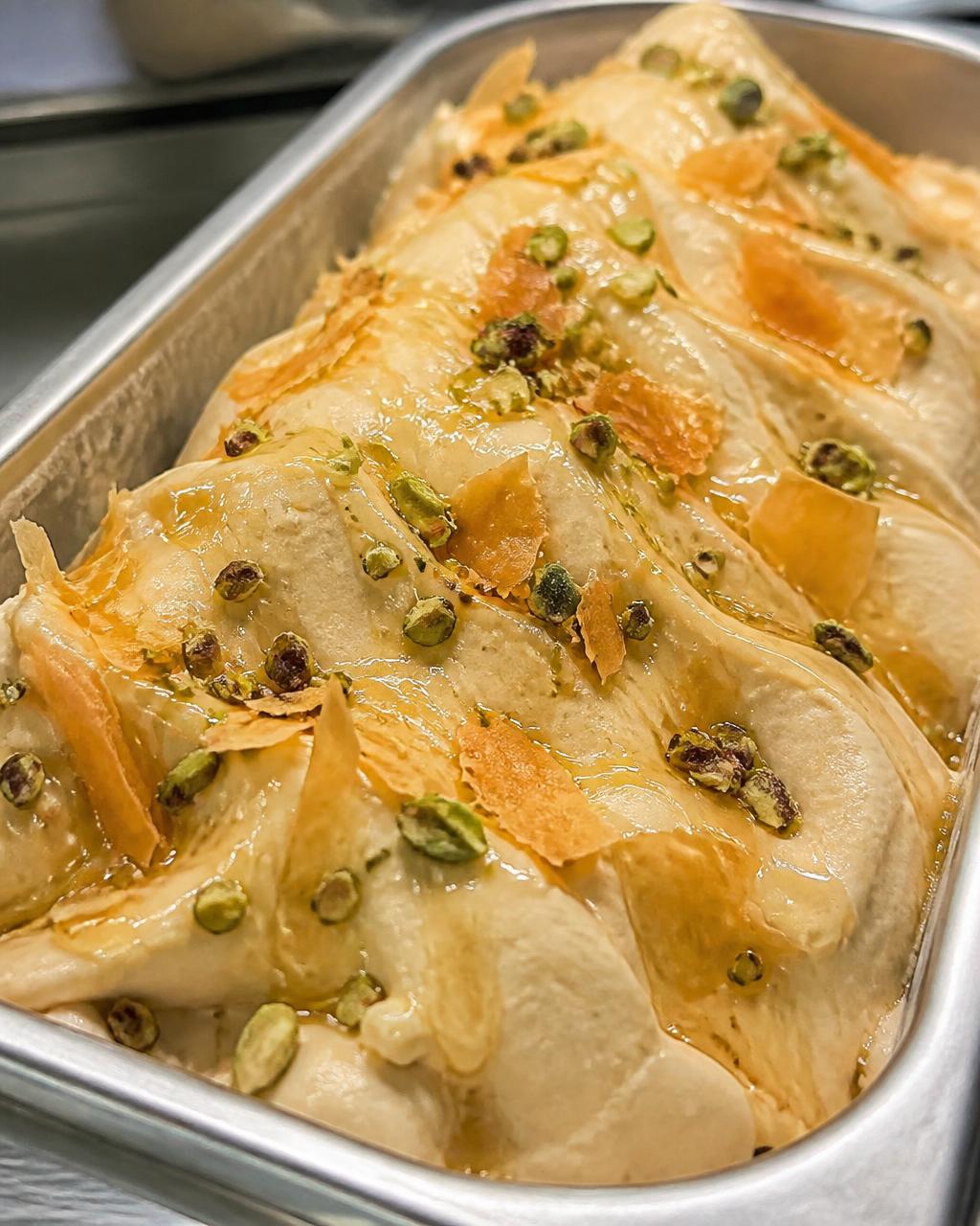 Baklava gelato with crushed pistachios, honey and flaky filo in a stainless steel gelato pan